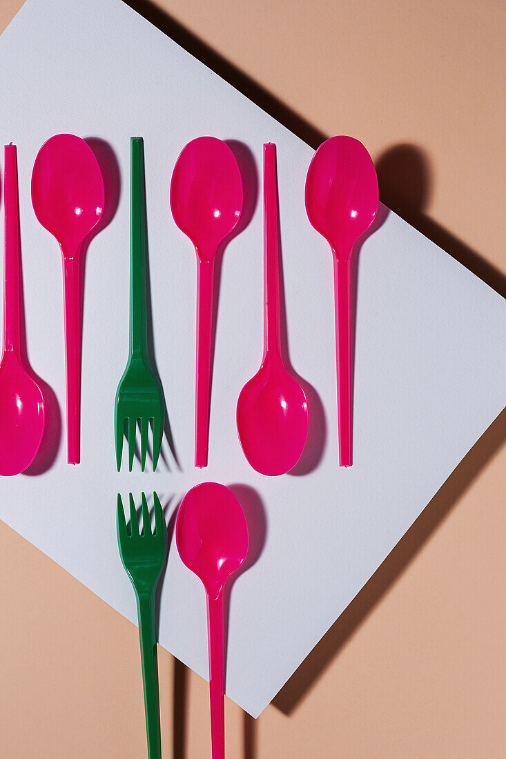 Overhead view of colorful eco friendly cutlery on pastel background