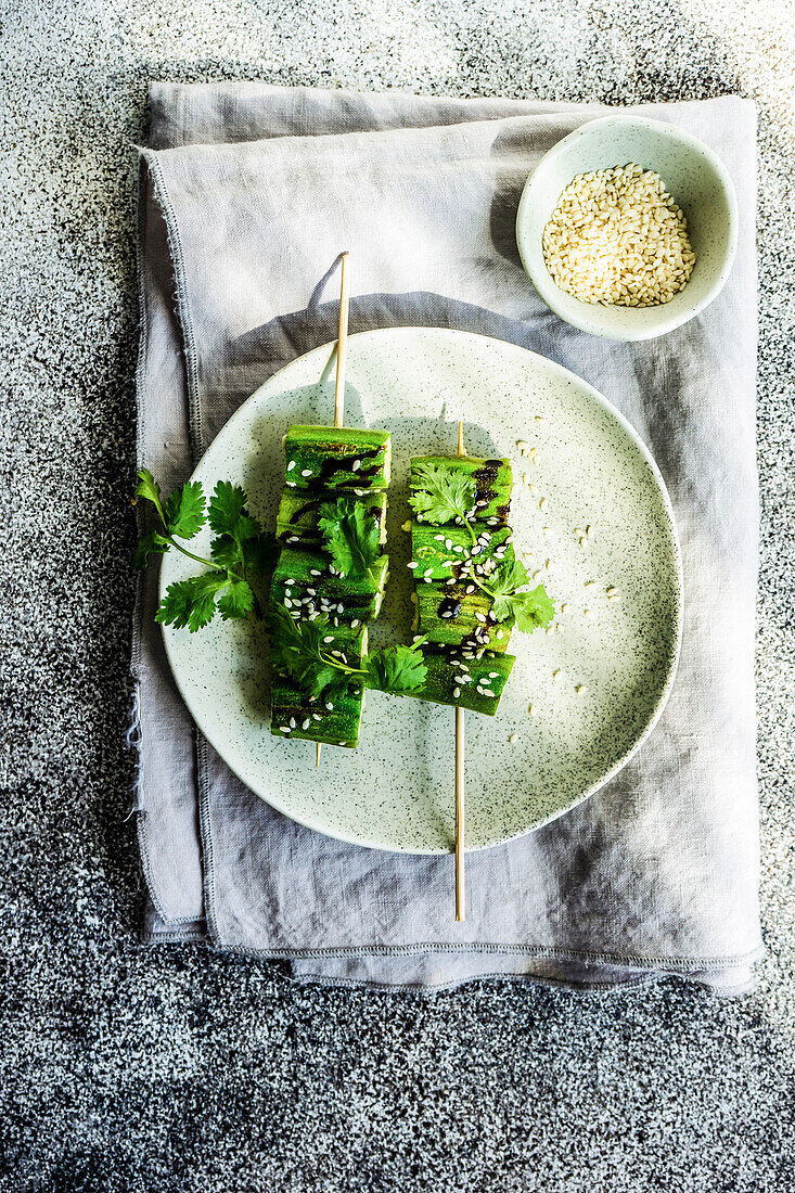 BBQ slices of okra with sesame seeds, coriander and soy sauce served on the plate