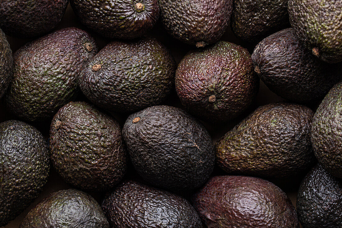 Vollbildansicht von oben mit ganzen reifen braunen Avocados als Hintergrund