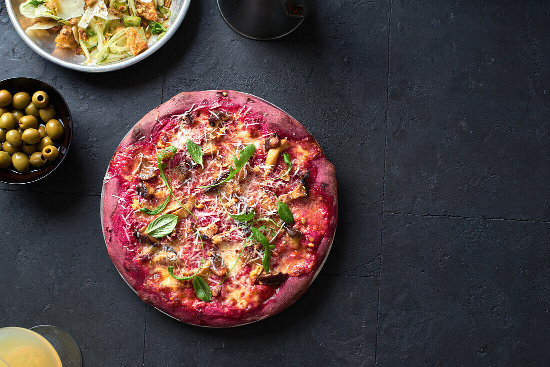 Lila gefärbte rustikale Pizza mit Roter Bete und vegetarischem Belag. Ansicht von oben gesundes Essen Rezept