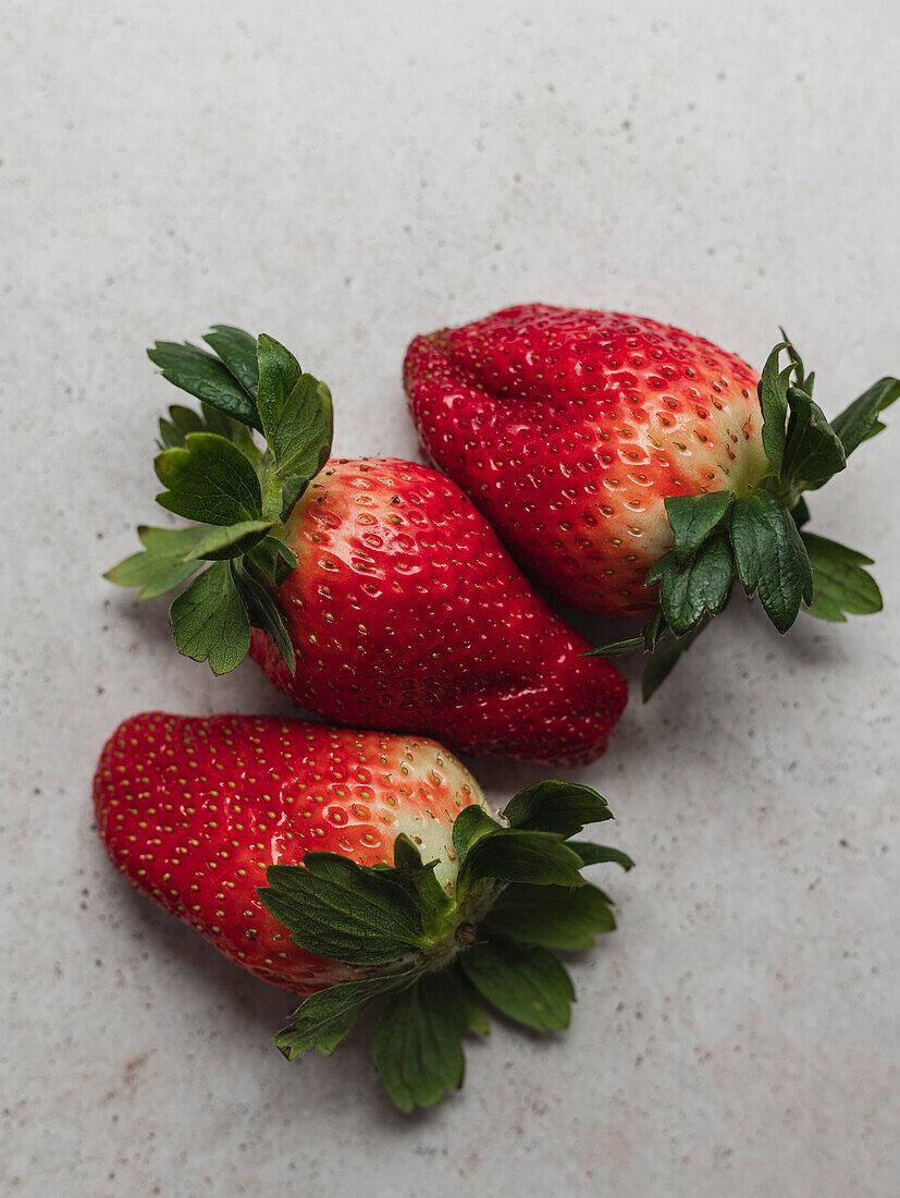 Blick von oben auf die Ernte eines Stapels frischer Erdbeeren, die auf einem Tisch in der Küche serviert werden