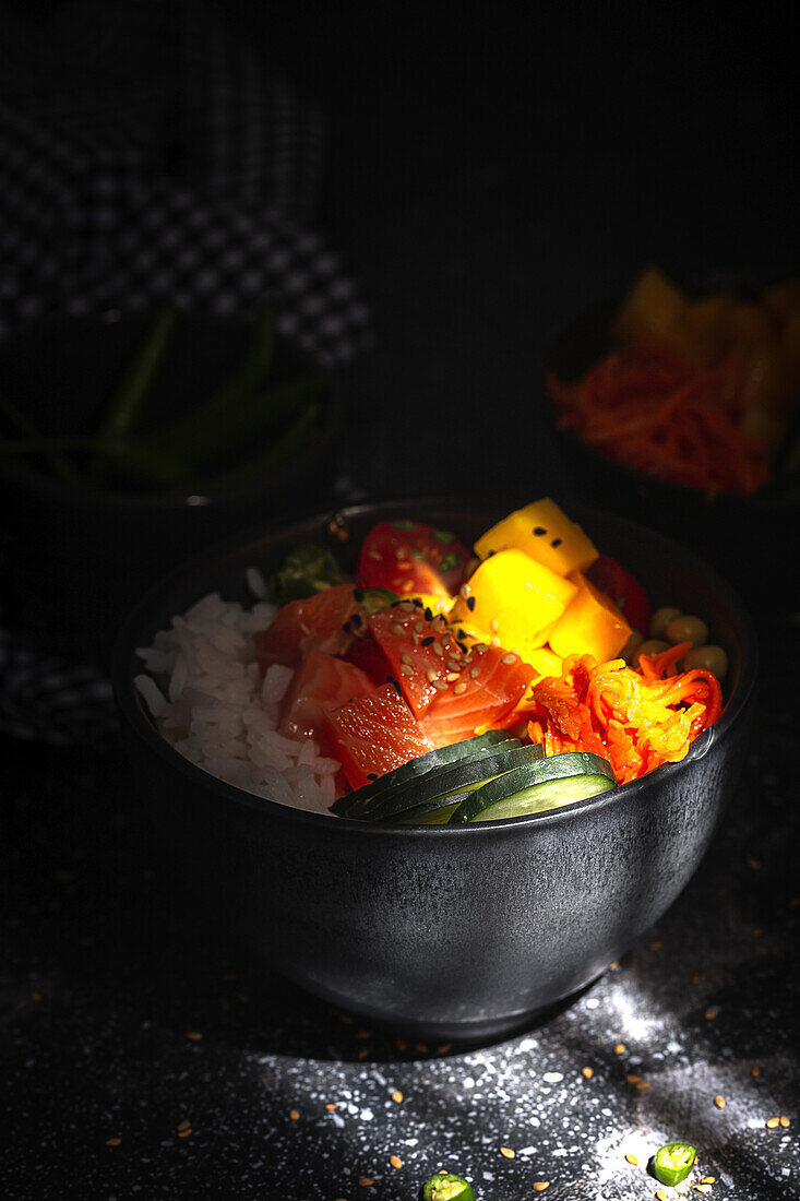 Asiatischer Poke mit Lachs und Reis mit verschiedenen Gemüsesorten, serviert in einer Schüssel auf einem Tisch in einem Restaurant