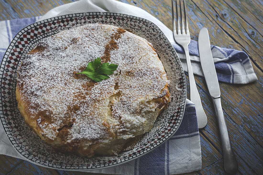 Top view of appetizing bastilla with aromatic spices on table near flower sprig during Ramadan holidays