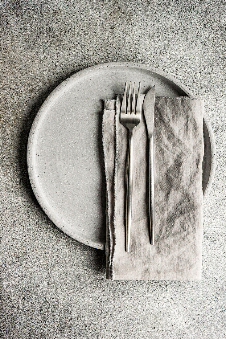Minimalistic grey monochrome dinner set with plate and cutlery