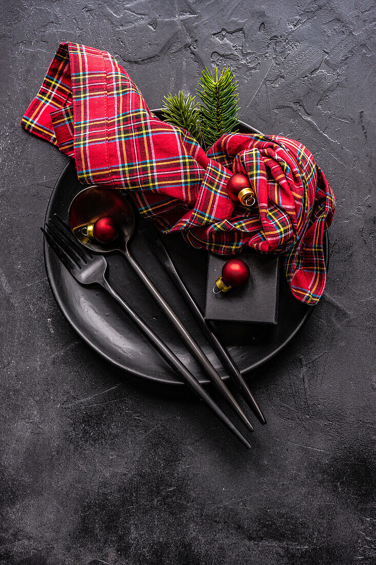 From above ceramic plate setting for Christmas dinner on concrete table on dark background