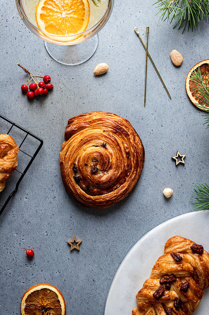 Draufsicht auf köstliches hausgemachtes Gebäck auf einer grauen Tafel mit Weihnachtsdekoration drum herum