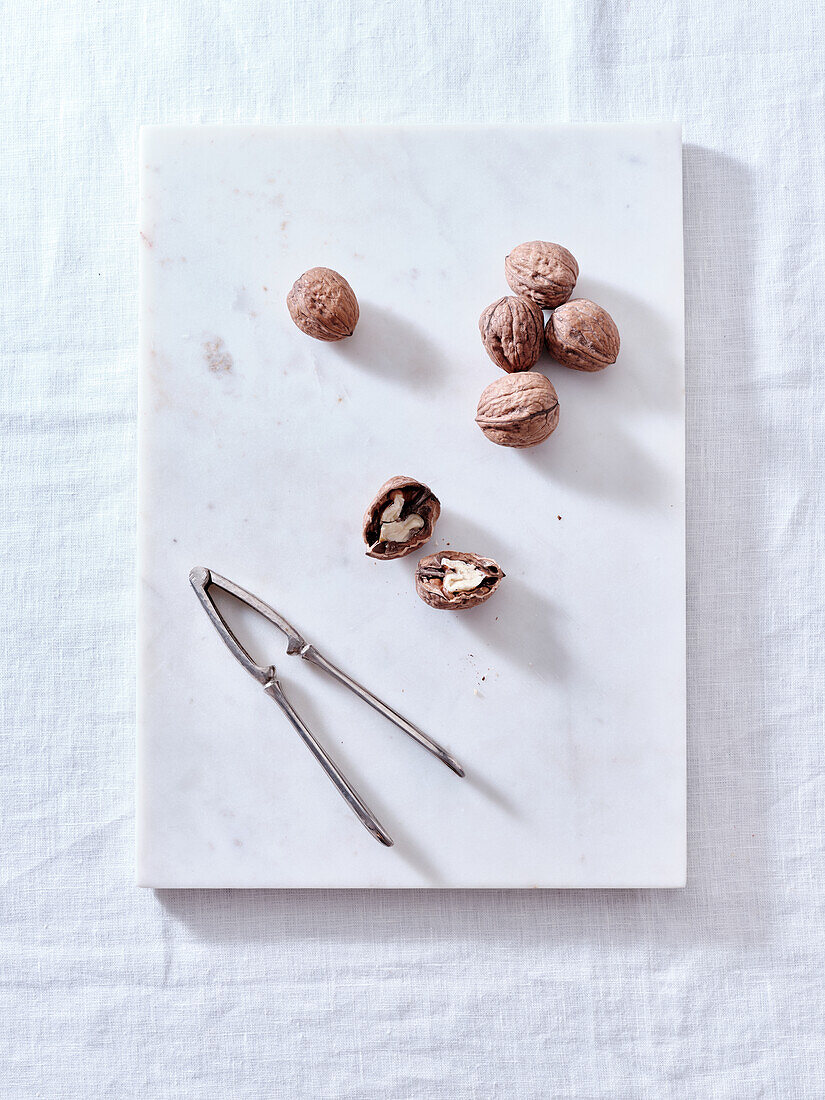 Opening walnuts with a cracker top view. White background