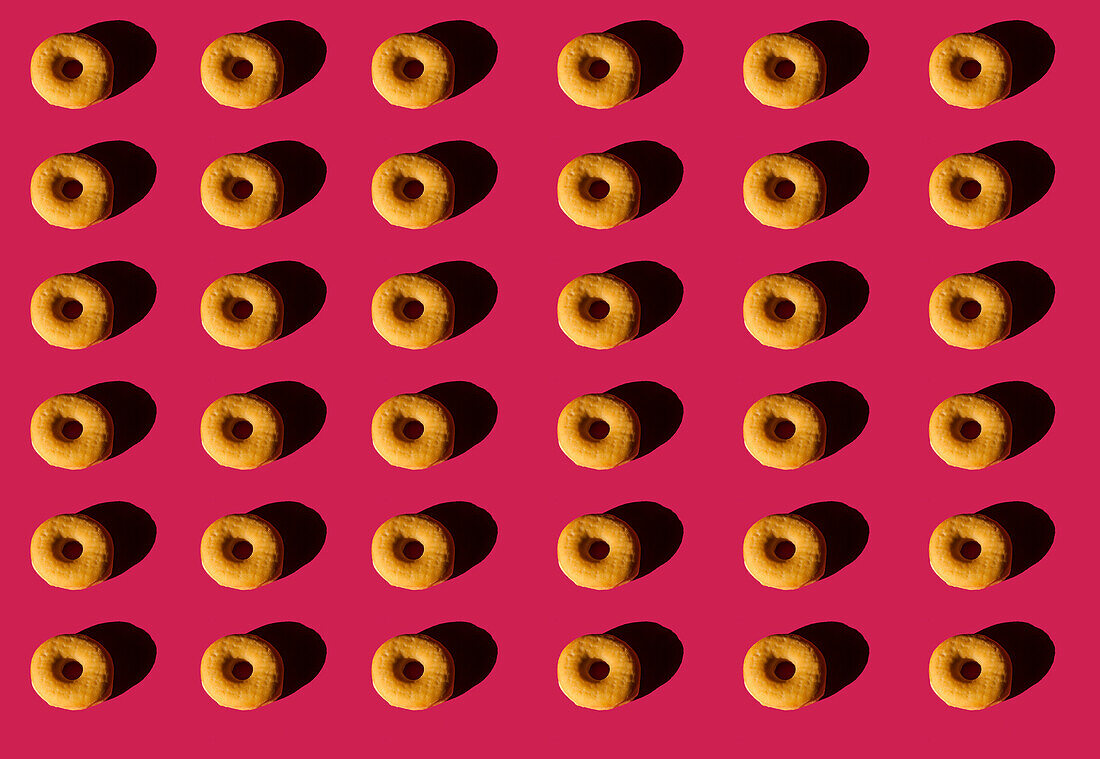 Blick von oben auf den Hintergrund von klassischen Donuts ohne Deckel auf rosa Hintergrund