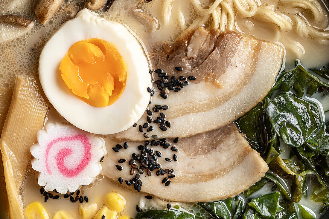 Nahaufnahme von appetitlichen japanischen Ramen mit gekochtem Ei und Pilzen in einer Schüssel serviert