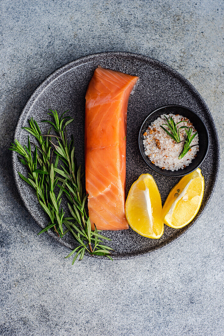 Healthy plate with salmon fish , lemons and rosemary herbs