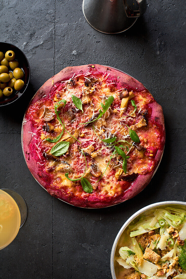 Purple colored rustic pizza with beetroot and vegetarian topping. Top view healthy food recipe