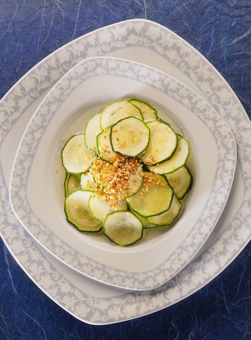 Marinated courgette slices with sesame on plate
