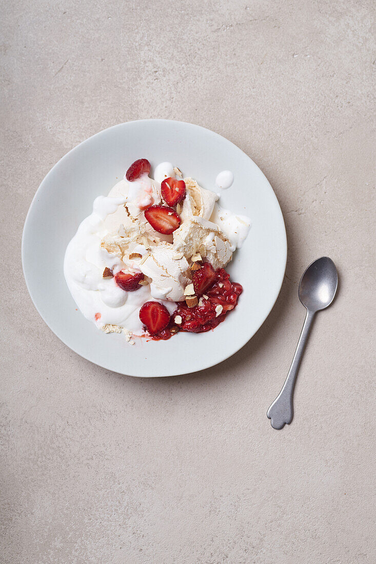 Dessert with strawberries, meringue and whipped cream viewed from above