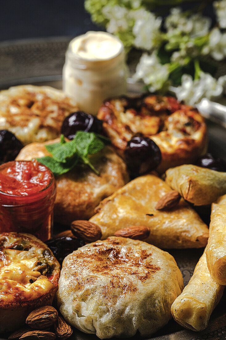 High angle of assorted tasty Arabic food with salsa and fresh mint leaves near almonds during Ramadan holidays