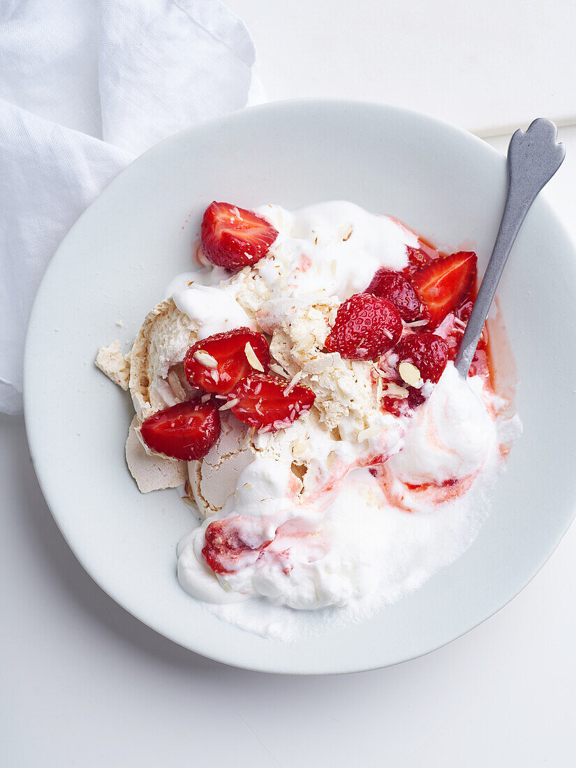 Dessert mit Beeren, Baiser und Schlagsahne. Nahaufnahme von Eton's Mess mit Erdbeeren, süße Leckerei mit Sommerstimmung