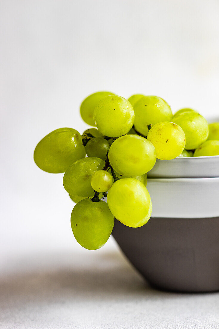 Stoneware with ripe green grape on concrete background