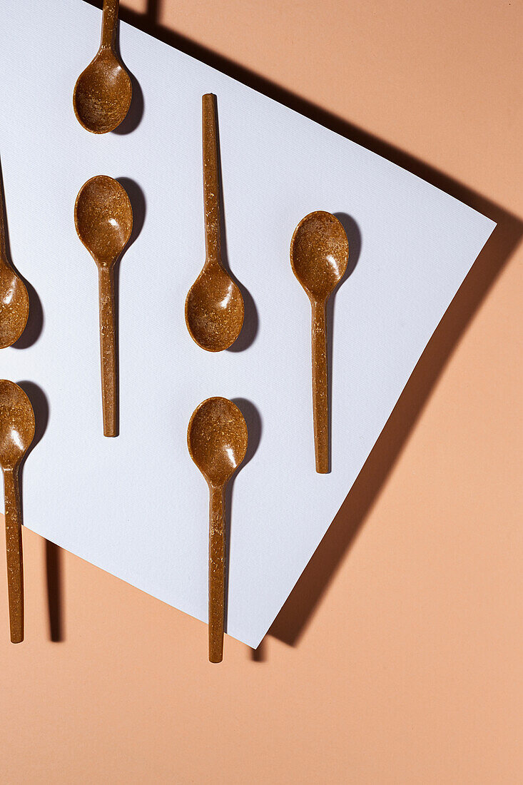 Overhead view of brown eco friendly spoons on pastel background
