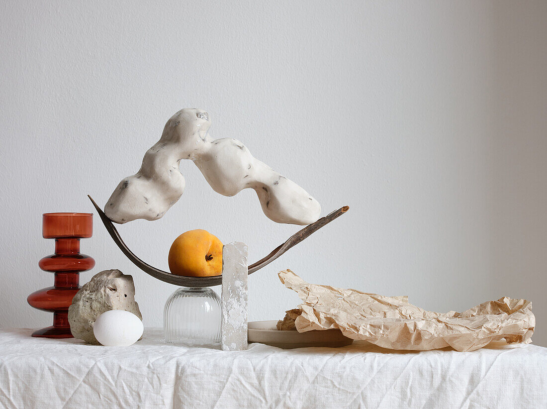 Arrangement mit handgefertigter Skulptur und einem Pfirsich