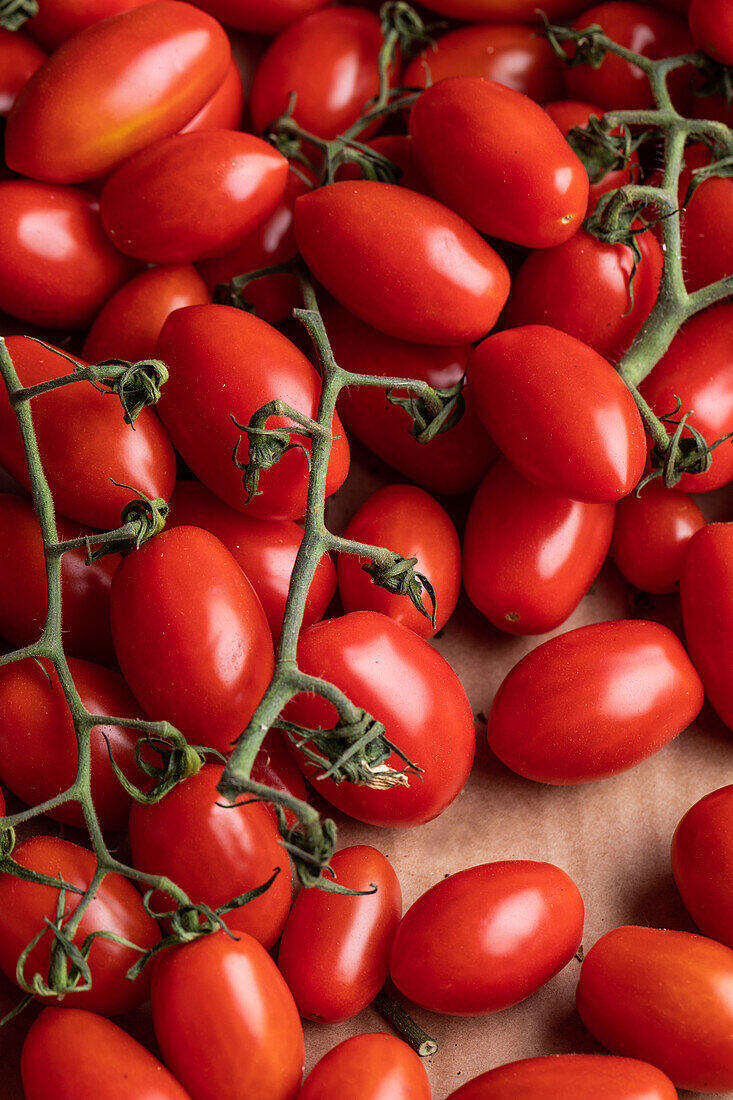 Top view of branch of delicious fresh red tomatoes placed on cardboard box
