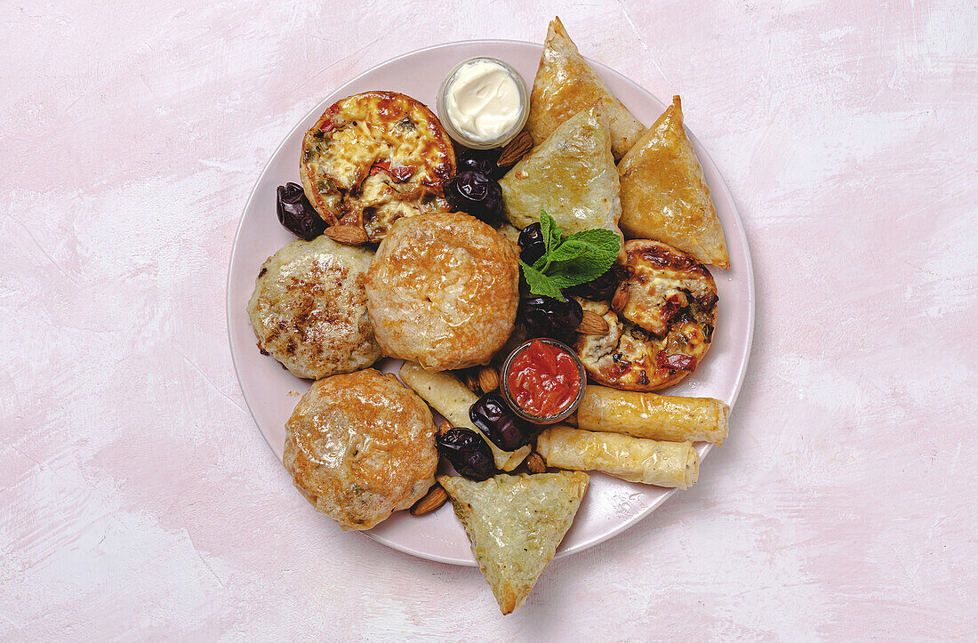 Blick von oben auf verschiedene leckere arabische Speisen mit Salsa und frischen Minzblättern in der Nähe von Mandeln während des Ramadan-Festes