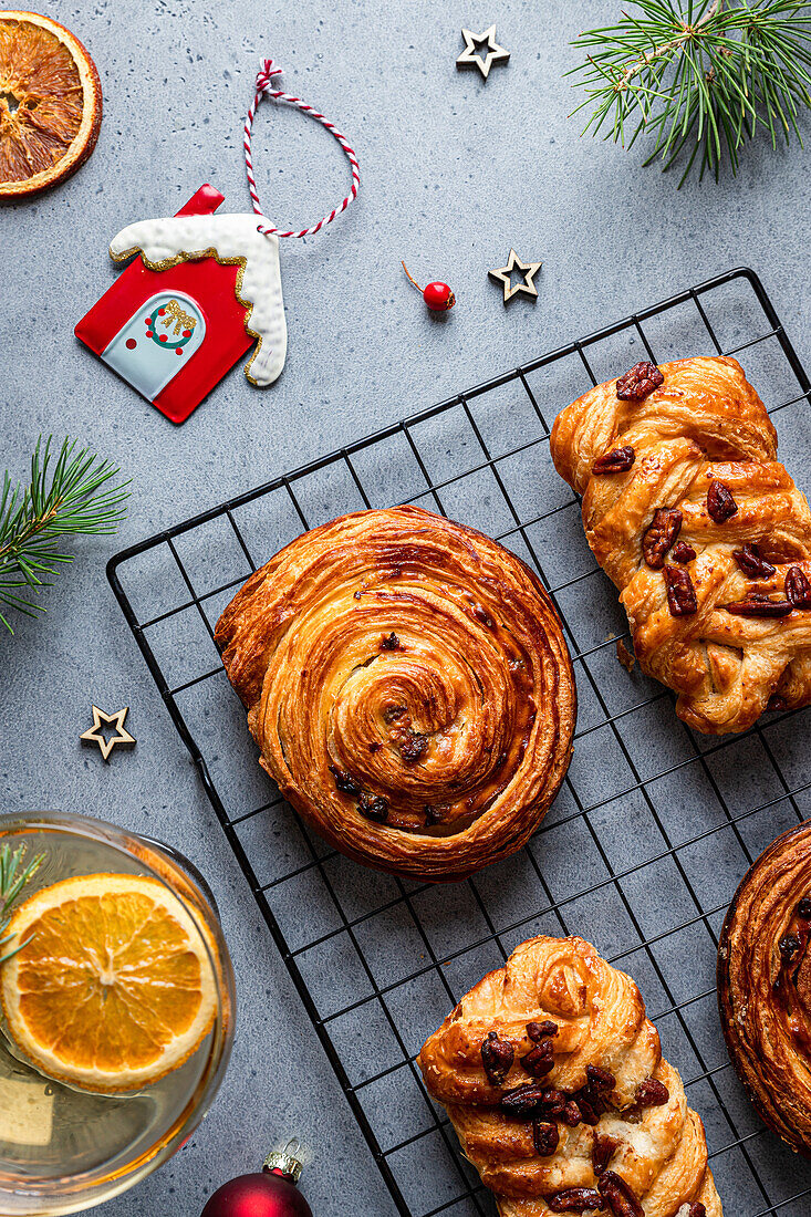 Draufsicht auf köstliches, hausgemachtes Gebäck auf einem schwarzen Gitter mit Weihnachtsdekoration