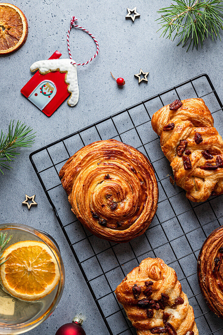 Top view of delicious homemade baked assorted pastries placed on black grid with Christmas decoration around