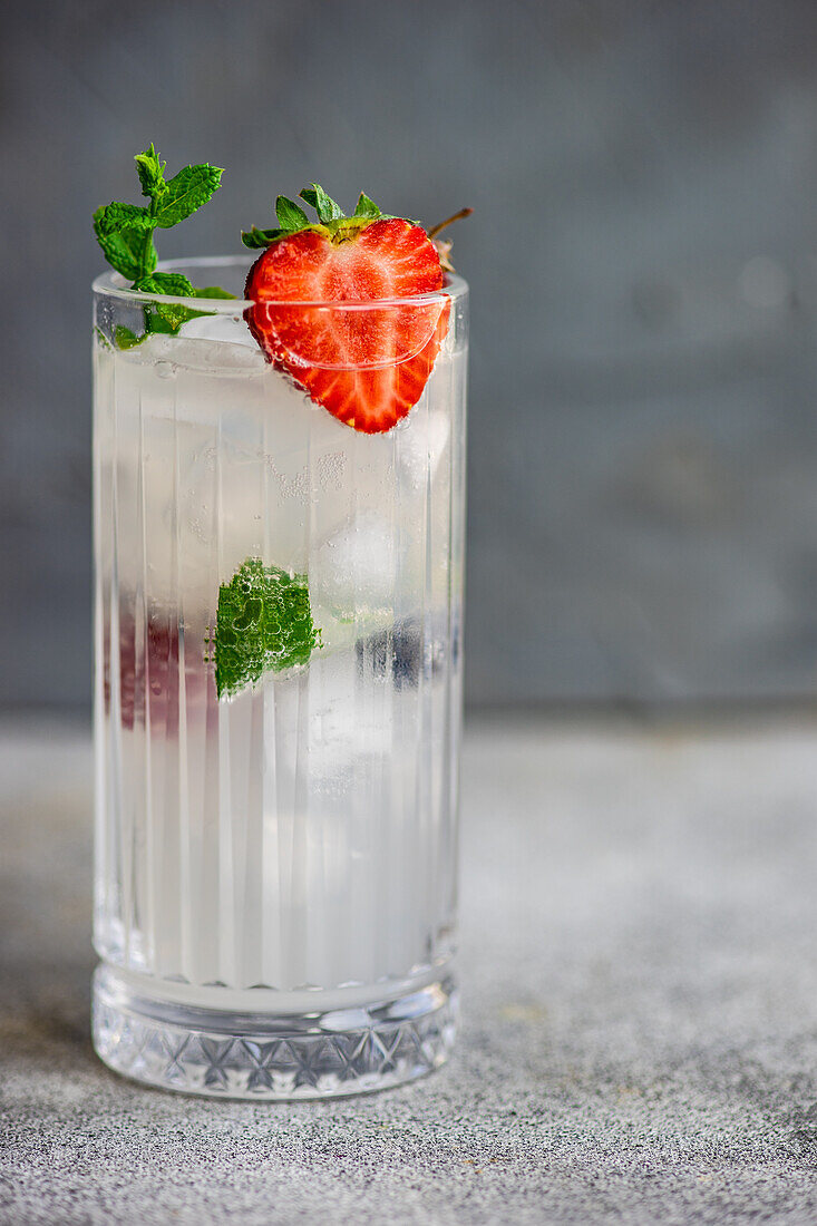 Summer cocktail with ice and berries served in the crystal glass