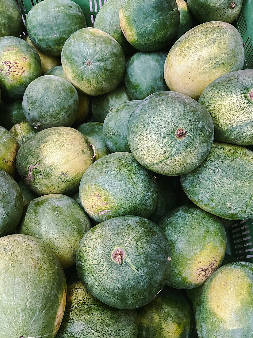 From above of heap of whole small green watermelons placed on stall in local Australian market