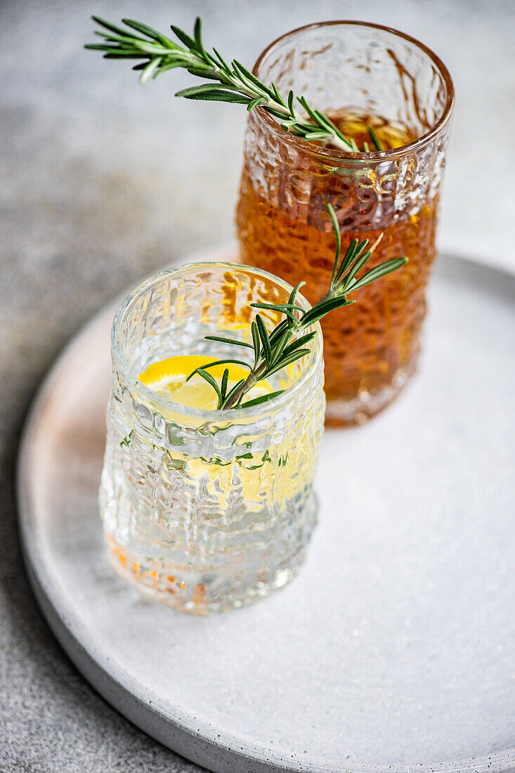 From above alcoholic cocktails in the crystal glass with fresh rosemary and lemon slice