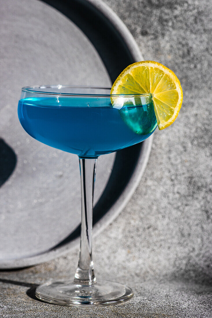Glas blaues Kamikaze-Getränk auf Steintisch im modernen Stil