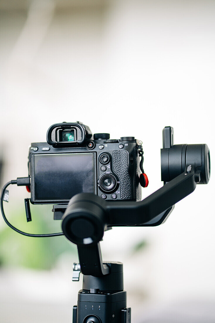 Zeitgenössische digitale Fotokamera mit Moduswahlrad und Sucher über dem Display auf unscharfem Hintergrund