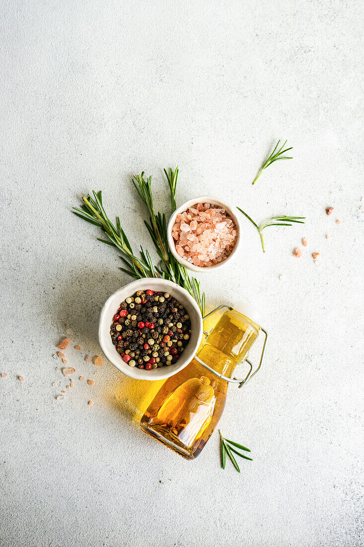 From above cooking concept with spices, olive oil and rosemary herb on concrete background