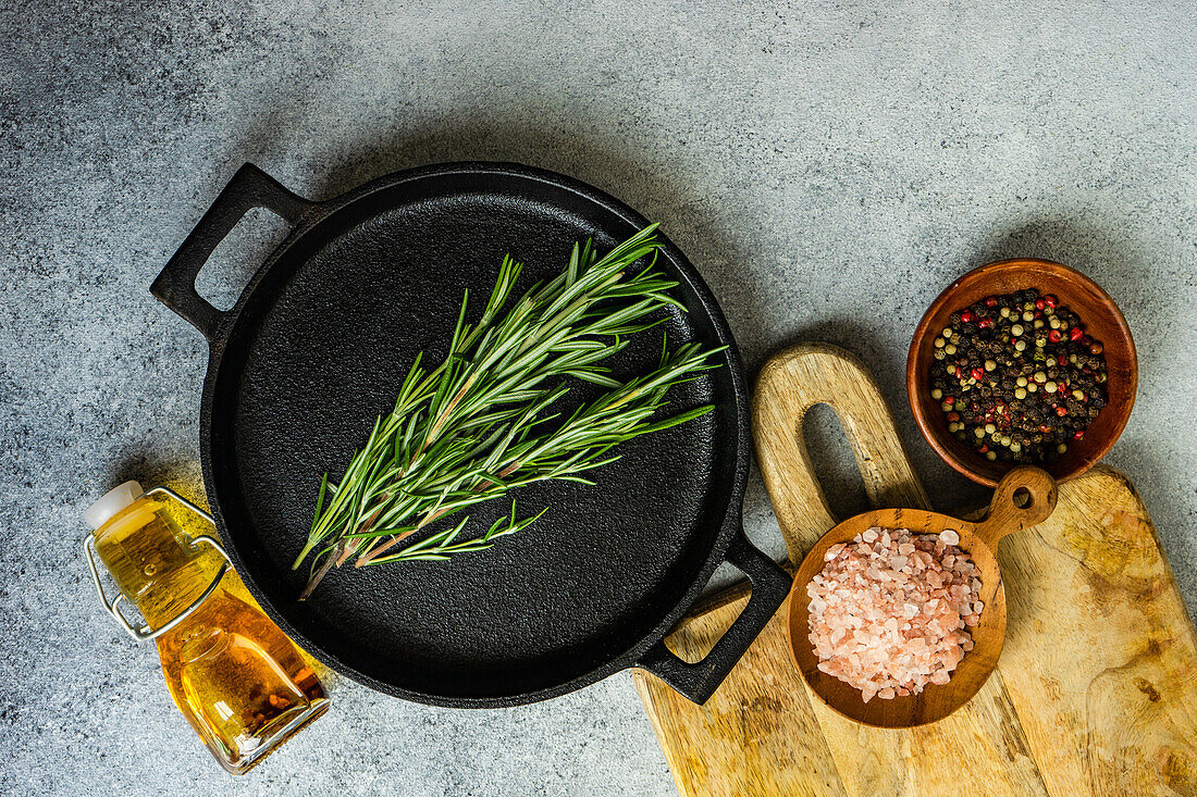 Top view of cooking concept with spices and rosemary herb on concrete background