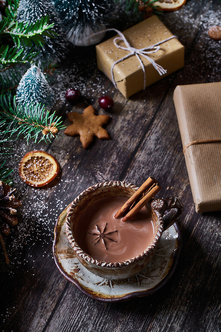 Von oben Schüssel mit Schokolade mit Weihnachtsdekoration auf Holztisch neben eingepackten Geschenken
