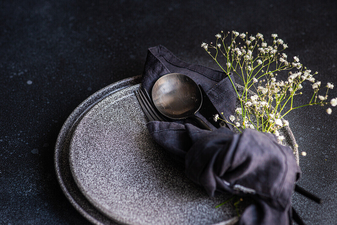 Rustic summer table setting with plate and cutlery decorated with cushion baby's-breath