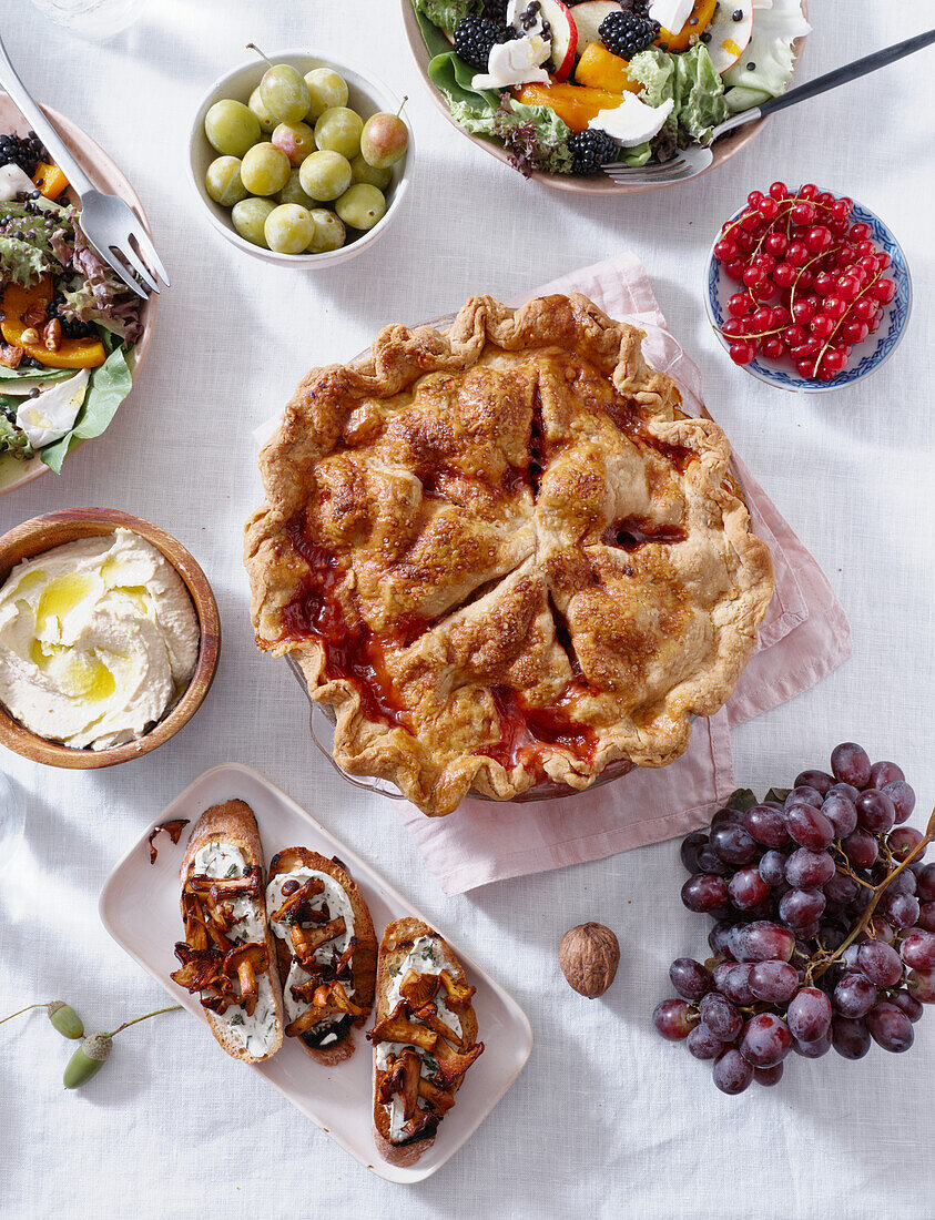 Vegetarisches Abendessen mit verschiedenen Snacks und Gerichten: Salatteller, Bruschetta, gebratenes Gemüse und ein Kuchen