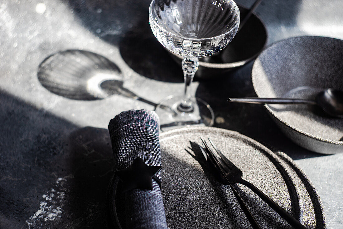 From above stone tableware arrange for dinner with deep shadows