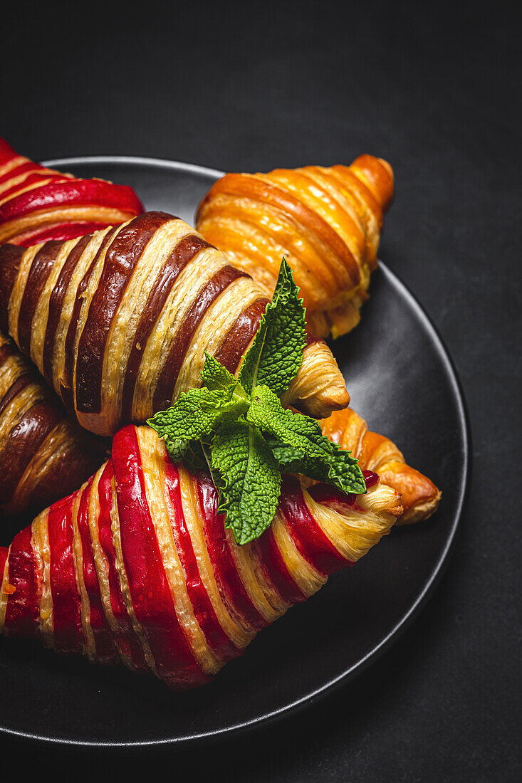 From above of assorted sweet croissants served in basket on table for breakfast