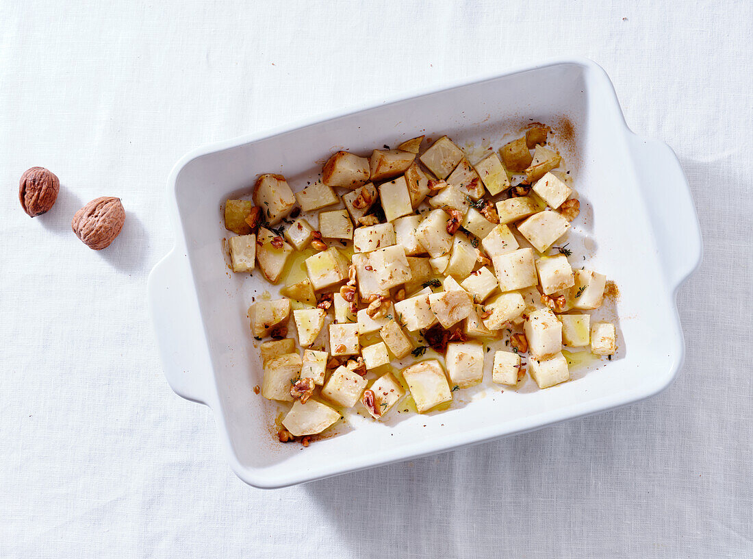 Roasted celeriac with walnuts and dressing top view. Vegetarian dinner concept