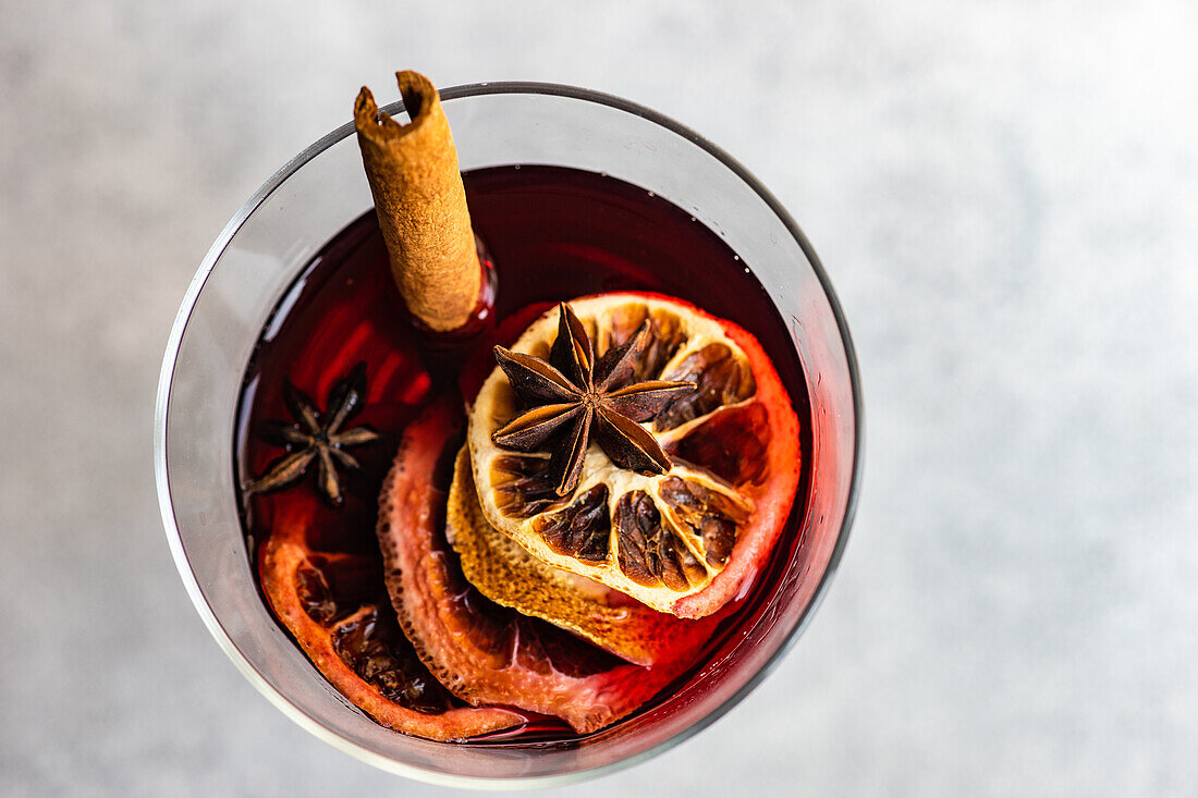 Overhead view of winter mulled wine with spices on concrete background