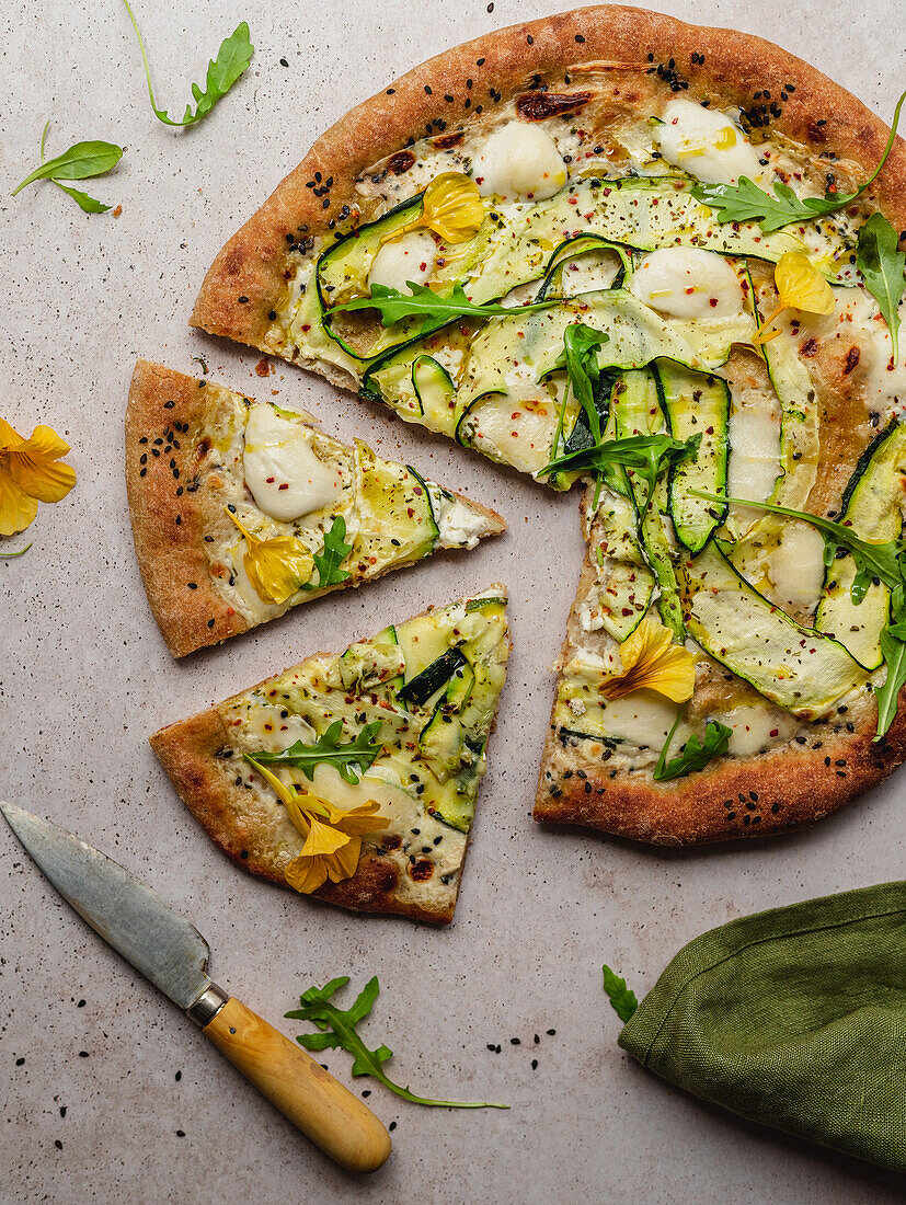 Top view of tasty pizza with arugula leaves on melted mozzarella cheese with black sesame seeds