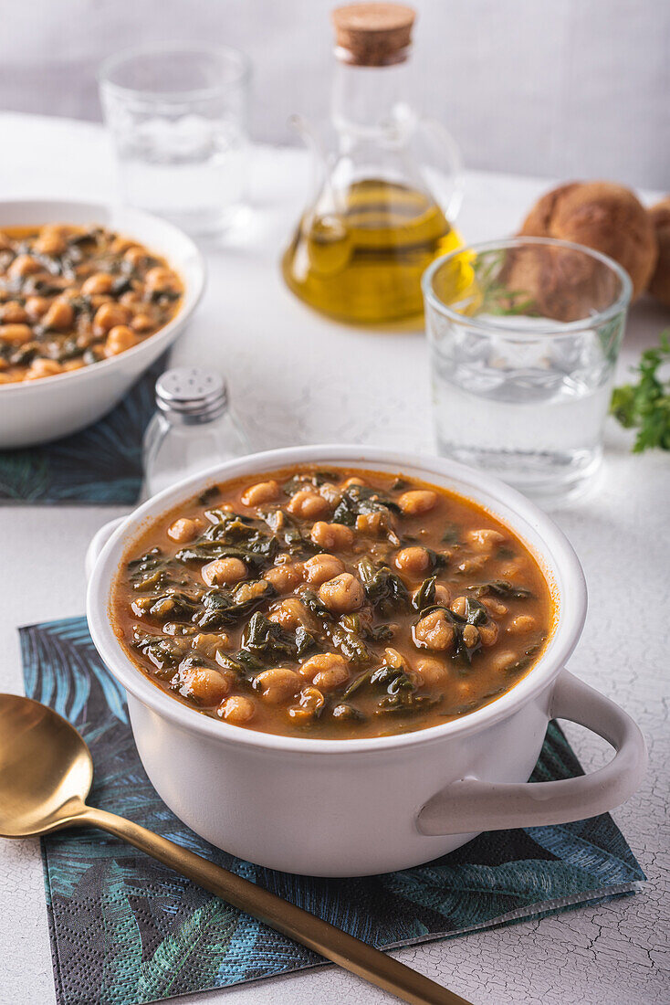 High angle of bowl with tasty chickpea soup served for lunch on paper napkin near spoon