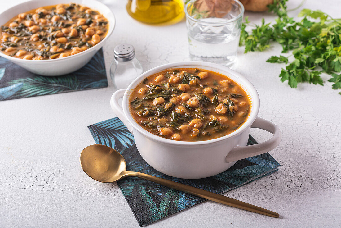 Schale mit leckerer Kichererbsensuppe zum Mittagessen auf Papierserviette neben Löffel