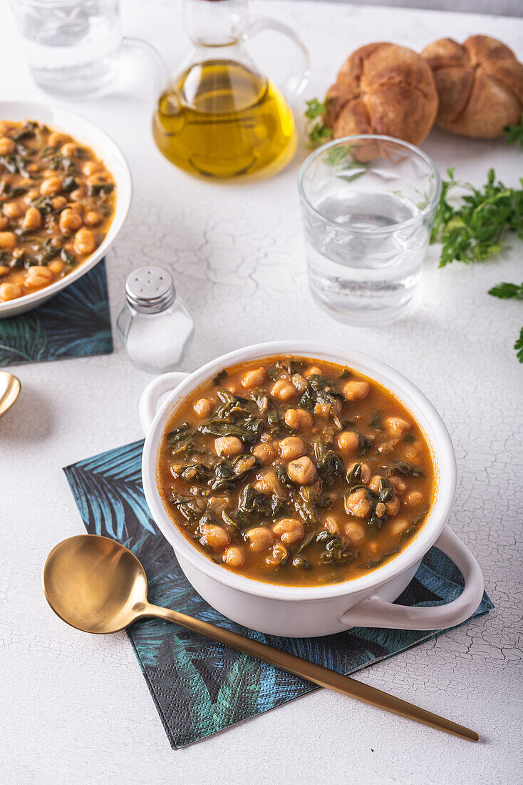 Schale mit leckerer Kichererbsensuppe zum Mittagessen auf Papierserviette neben Löffel