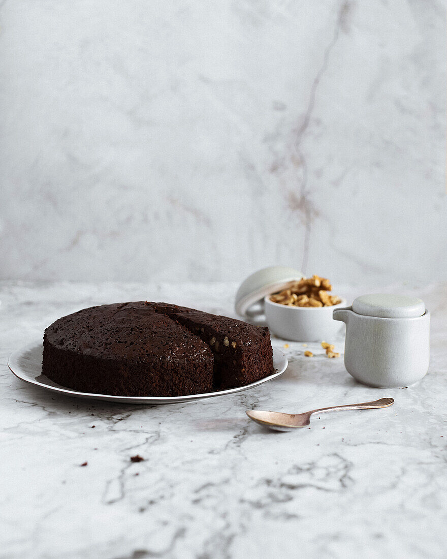 Front view brownie cake on a plate on white marble background