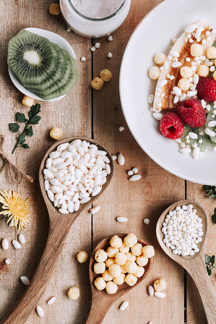 Blick von oben auf eine Schale mit frischen Früchten und Beeren auf einem rustikalen Holztisch