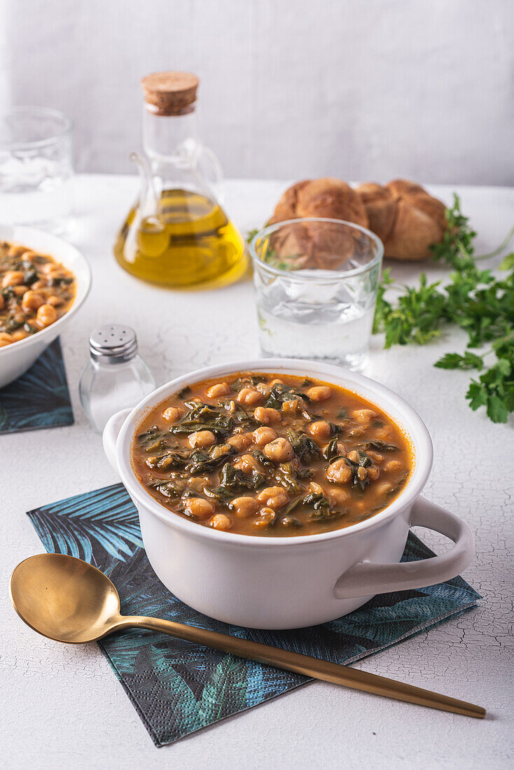 High angle of bowl with tasty chickpea soup served for lunch on paper napkin near spoon