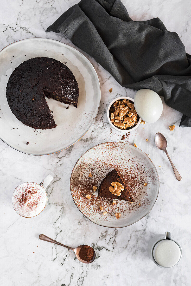 Draufsicht auf Brownie-Kuchen auf einem Teller vor weißem Marmor-Hintergrund