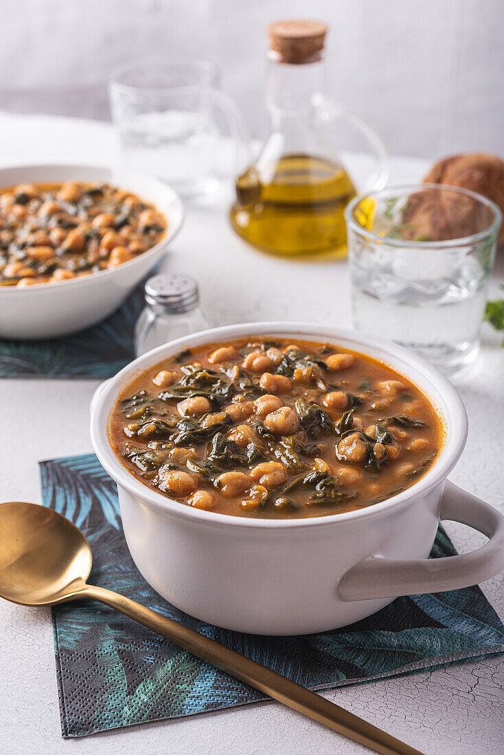 Schale mit leckerer Kichererbsensuppe zum Mittagessen auf Papierserviette neben Löffel