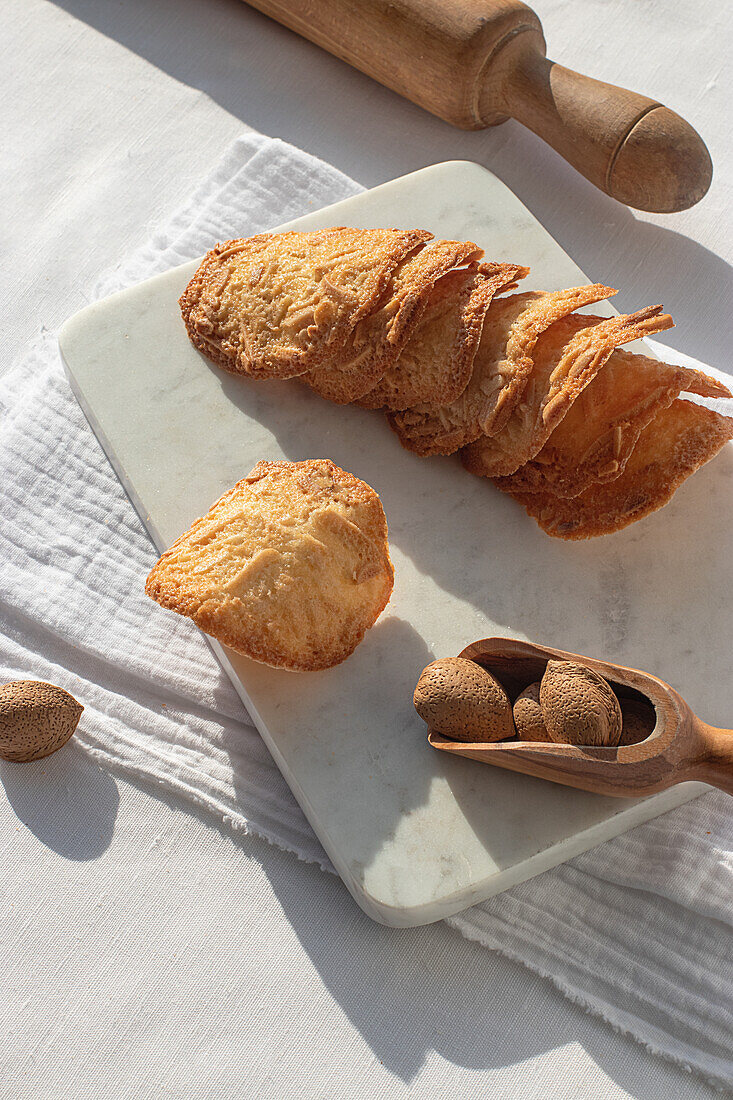 Top view of delicious Almond Tiles cookies placed on plate on tablecloth